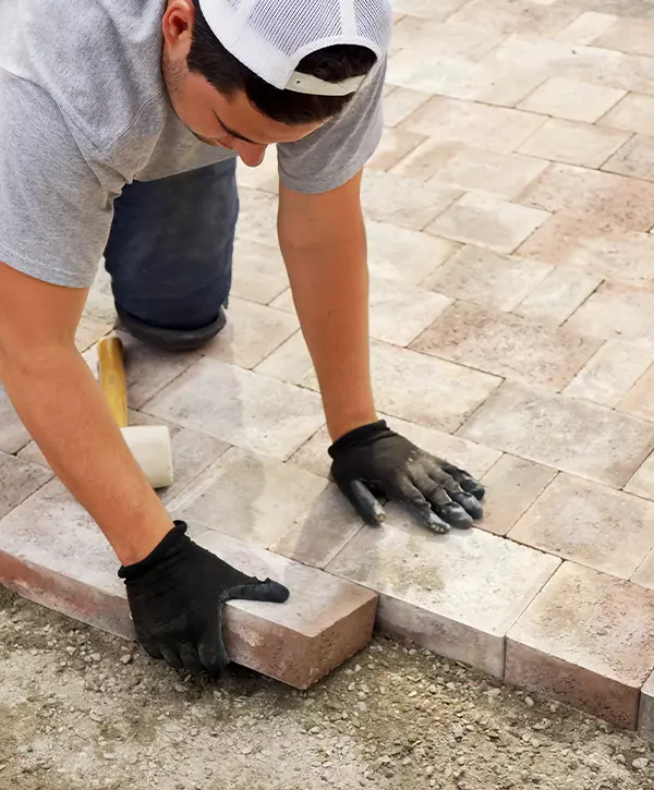 Worker installing Paver stone in Little Elm TX