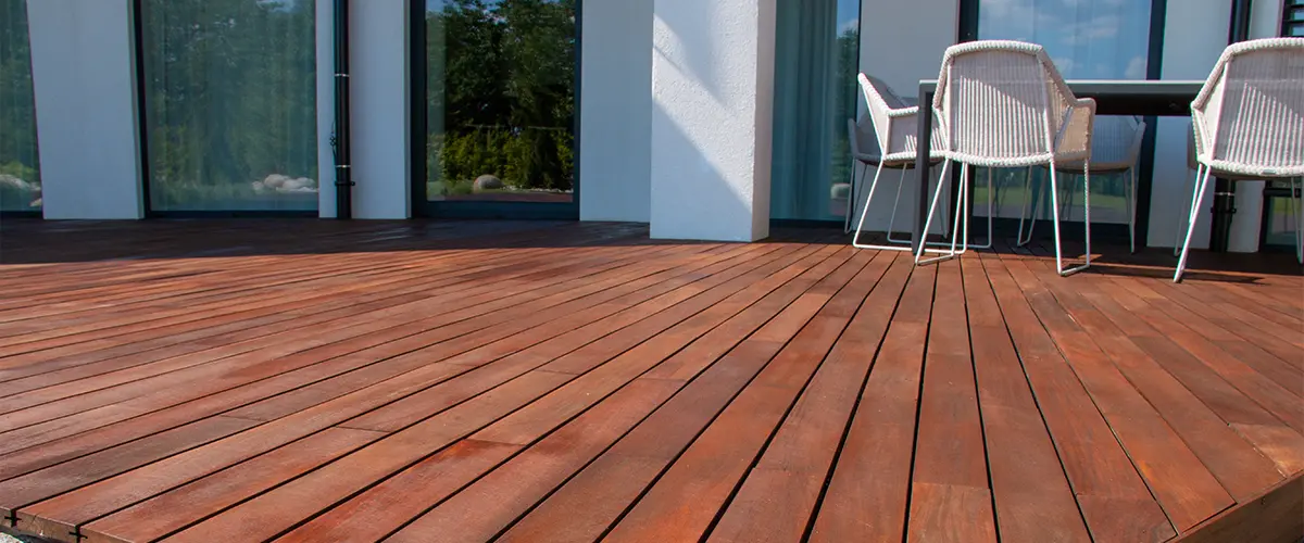 Modern wooden deck design in Plano, featuring rich wood tones and outdoor seating, enhancing the home's exterior space.