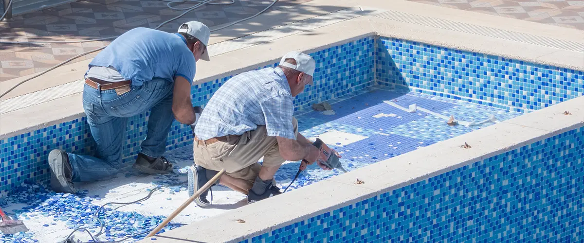 Pool builders in Plano, TX working on tile installation for quality pool construction