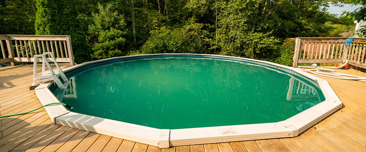 Home pool. A small rubber swimming pool with a deck in an home backyard