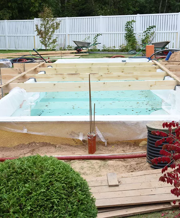 Fiberglass swimming pool construction building. Garden or backyard landscape works for swimming pool installation