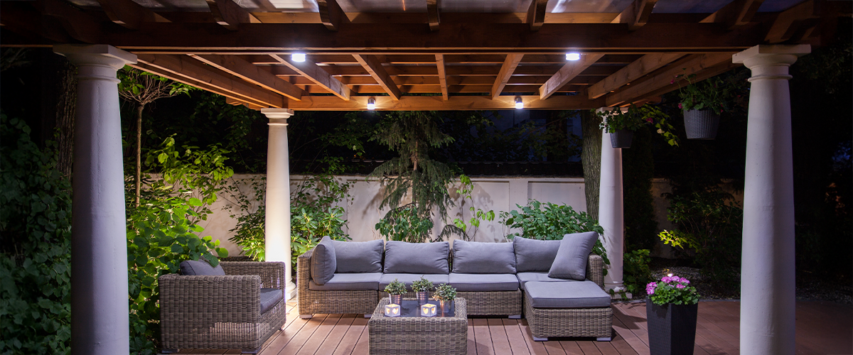 Outdoor pergola seating area with cozy lighting, perfect for evening relaxation and entertaining.